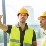 Technicians conducting HVAC system planning and load calculations.